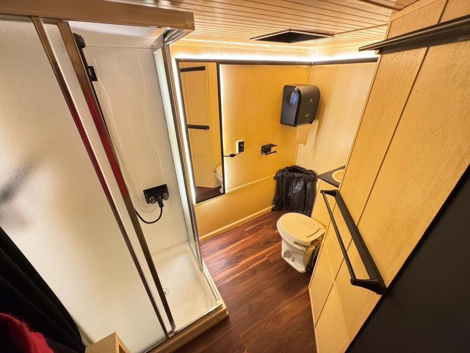 Onboard shower, sink, and washroom inside the sauna trailer